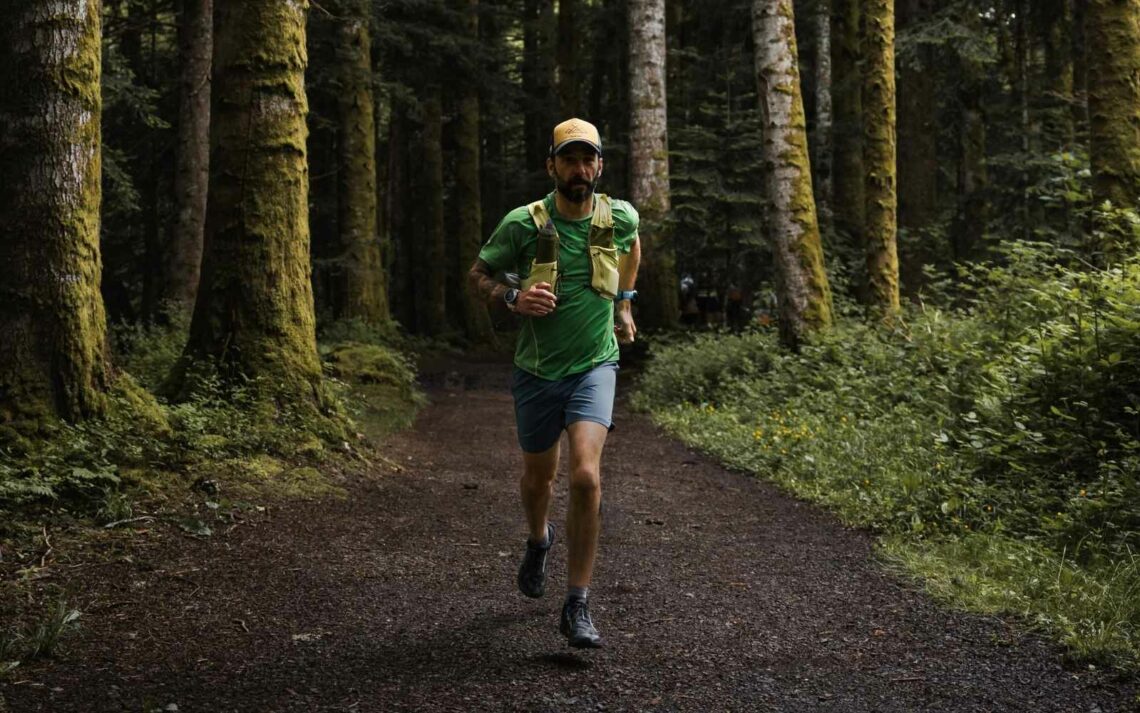 Homme qui fait du trail seul dans la forêt