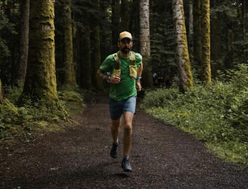 Homme qui fait du trail seul dans la forêt