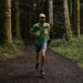 Homme qui fait du trail seul dans la forêt